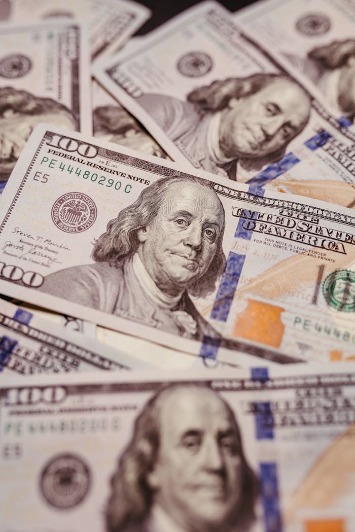 High-resolution shot of US hundred dollar bills laid out, showcasing Benjamin Franklin.